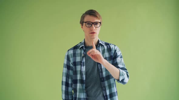 Portrait of Handsome Person Making Hush Gesture Touching Mouth with Finger