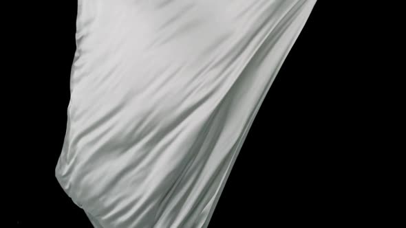 White fabric flowing on black background, Slow Motion