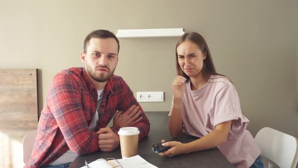 Pleasant Nice Husband and Wife Sitting at Table in Hotel Room Watching Tv