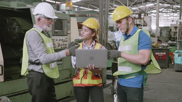 Group of team engineer meeting in industrial factory, foreman and labor talking and using laptop.