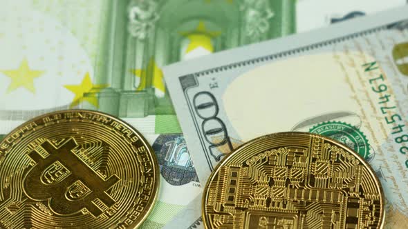 Close-up bitcoins on 100 dollar and 100 euro bills rotate. Buying and selling cryptocurrency