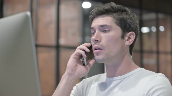 Young Man Talking on Phone at Work