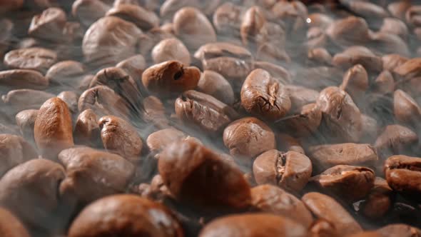 Close Up of Seeds of Coffee. Fragrant Coffee Beans Are Roasted Smoke Comes From Coffee Beans.