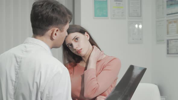 Woman with Neck Pain Talking to Her Doctor After Xray Scanning