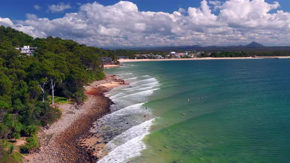 Scenic View Of Beach With Surfers During Summer In Noosa Heads, Queensland, Australia - aerial drone