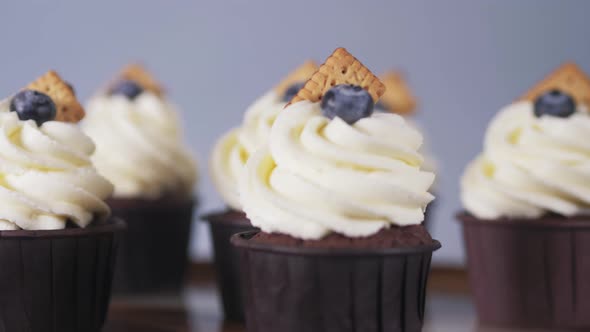 Closeup Rotation of Chocolate Cupcakes with Light Cream with Cookies and Berry