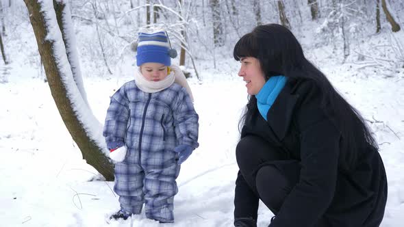 Happy Mother And Her Child Walk And Play In Park Covered With Snow 6