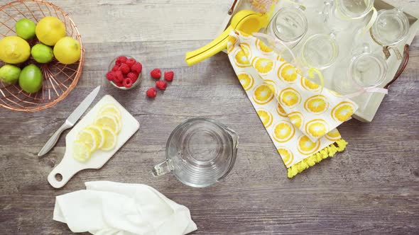 Step by step. Preparing raspberry lemonade with fresh lemons and raspberries in drinking mason jars.