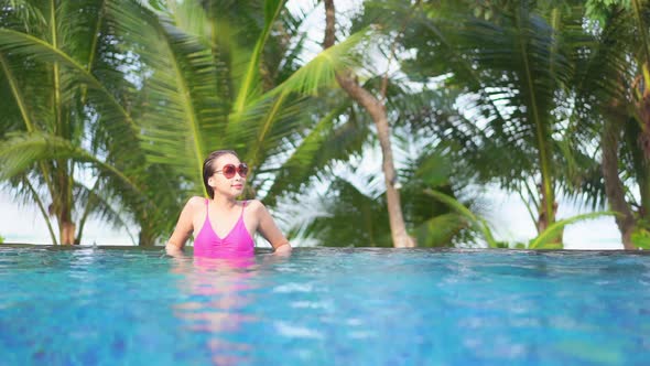 Young asian woman enjoy around outdoor swimming pool for leisure