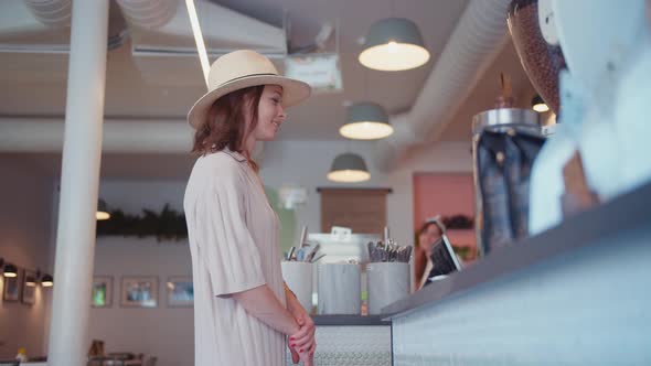 Smiling girl at the counter in a cafe