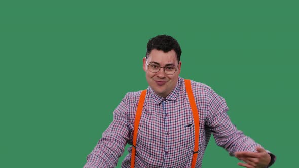 A Positive Man in Glasses in a Plaid Shirt with Orange Suspenders is Having Fun Dancing Moving