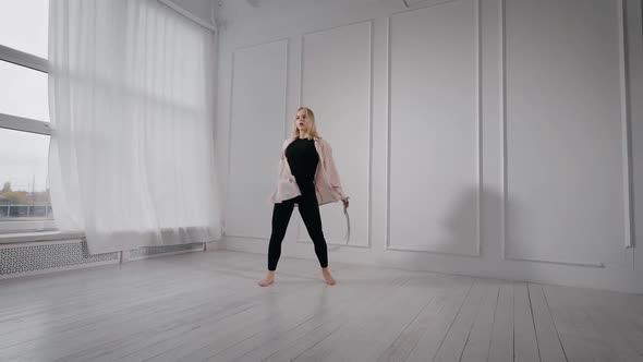 Young Pretty Blonde Woman Is Rehearsing Her Dance Performance in White Dancing Hall