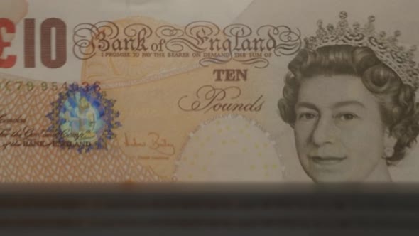 10 English Pound banknotes in cash machine. UK cash counting video.
