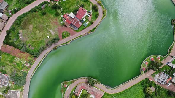 Right to left circular panning aerial view over the blue water and roads in small Mexican village