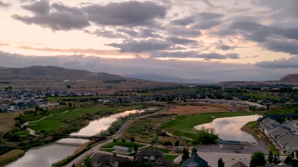 Stunning sunset aerial hyperlapse of an idyllic community along a river and golf course