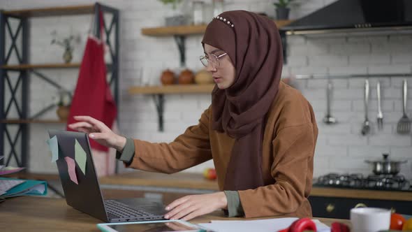 Busy Young Woman in Hijab Closing Laptop and Praying in Home Office