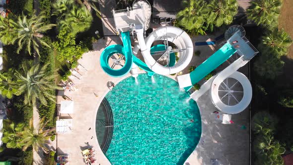 Fly Over a Large Pool with Blue Water and a Lot of Tourists in Hot Weather