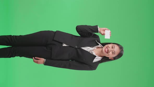 An Asian Business Woman With Smile Holding A White Card While Standing In Front Of Green Screen