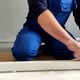 A Man a Handyman in a Blue Jumpsuit is Assembling a Table in Closeup - VideoHive Item for Sale