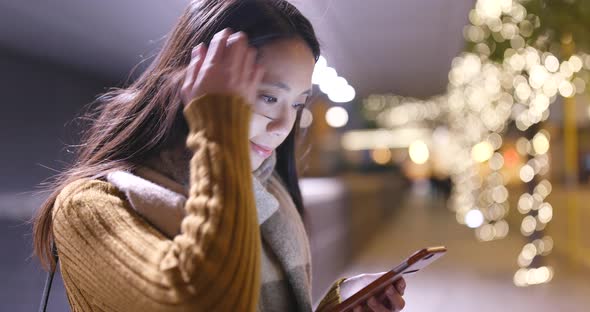 Asian Woman use of cellphone at night in the city