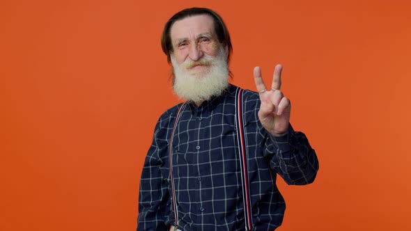 Senior Bearded Man Showing Victory Sign Hoping for Success and Win Doing Peace Gesture and Smiling