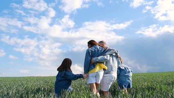 A Very Happy Family Hugs in the Middle of a Wheat Field