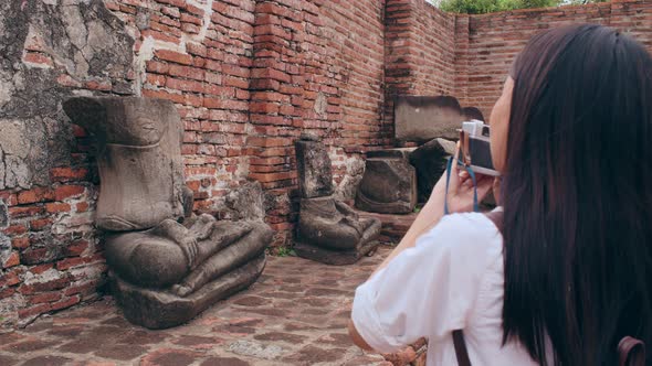 Asian woman using camera for take a picture while spending holiday trip at Ayutthaya,