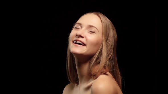 Girl with Braces and a Beautiful Hair Color Turns To the Camera and Laughs. Black