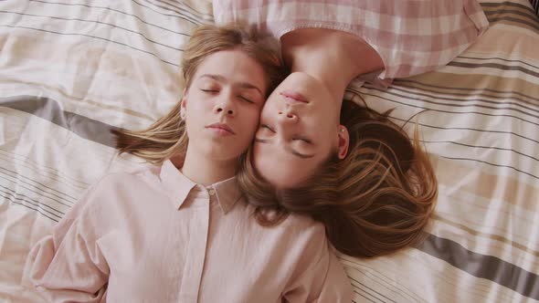 Twin Sisters Lying on Bed