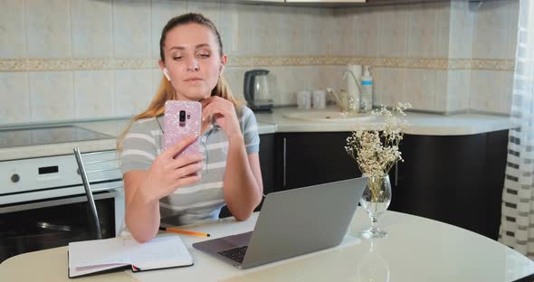 Student Pulls Faces on Video Call Holding Pink Smartphone