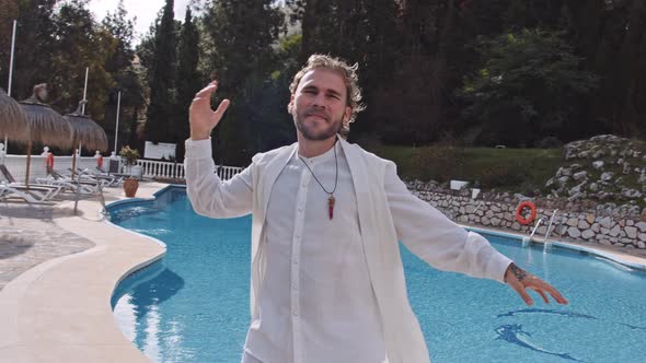 Man In White Robes Dancing By Swimming Pool