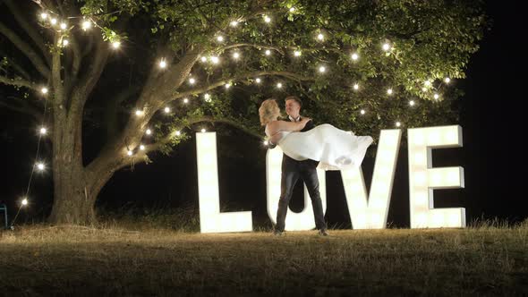 Groom holding bride in his arms