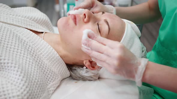 Female Beautician Makes Face Rejuvenation and Cleansing Procedure for Girl