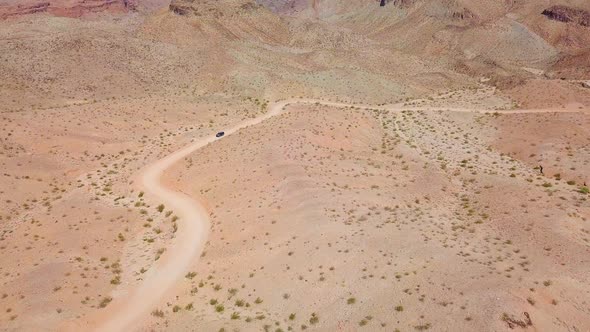 Aerial drone view of a car desert dirt road, in sunny Kingman wash, Arizona, USA