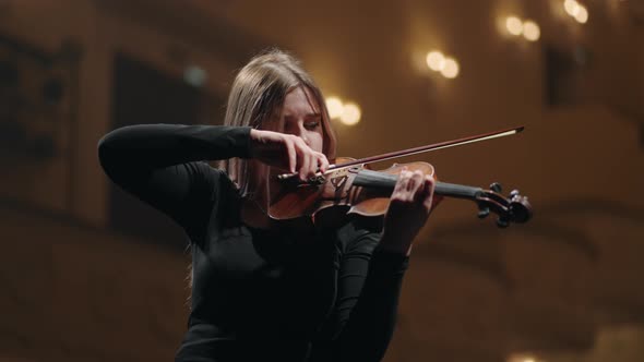 Young Female Violinist is Learning to Play Violin in Rehersal Hall or on Scene in Opera House or