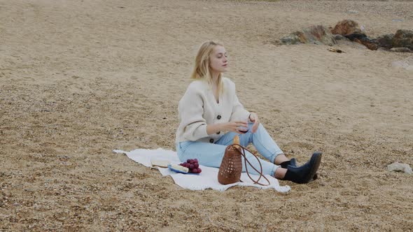 Woman Enjoys Picnic On Beach