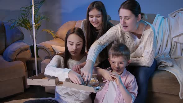 Big Family Eating Pizza and Taking Slices From Box While Watching TV Show or Movie in Living Room