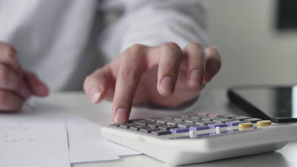 Close up hand Asian businessman using a calculator Calculation the expenditure budgets.