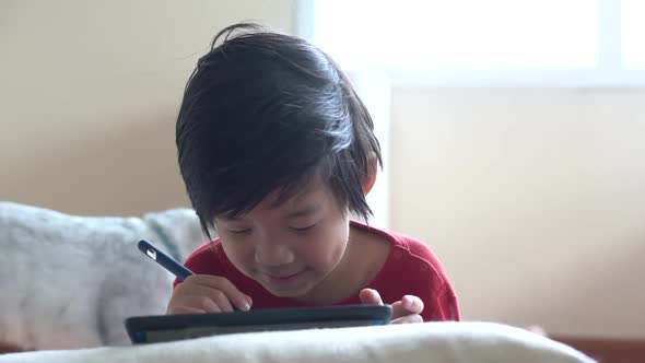 Asian Child Drawing Picture With Digital Pen On Tablet Pc Computer 