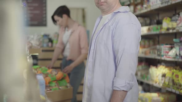 Unrecognizable Adult Man Stealing Cookies in Food Market. Caucasian Robber Taking Packaging and