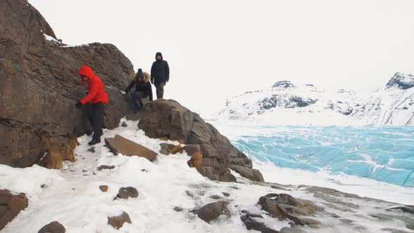 Group of Friends Travelers Walks Around Huge Glacier in Iceland