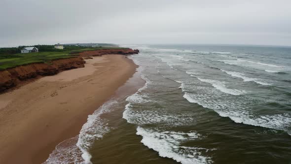 Aerial view of the waves approaching the empty Thunder Cove Beach on a grey, cloudy day.