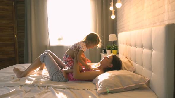 Mom With Daughter At Home On The Bed