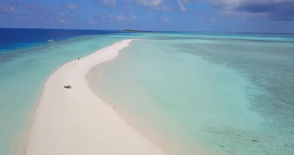 Wide drone island view of a white sandy paradise beach and blue ocean background in colourful 4K