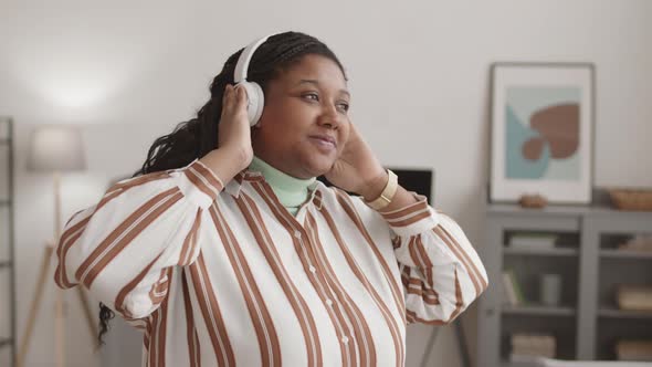 African-American Woman Listening to Music through Headphones