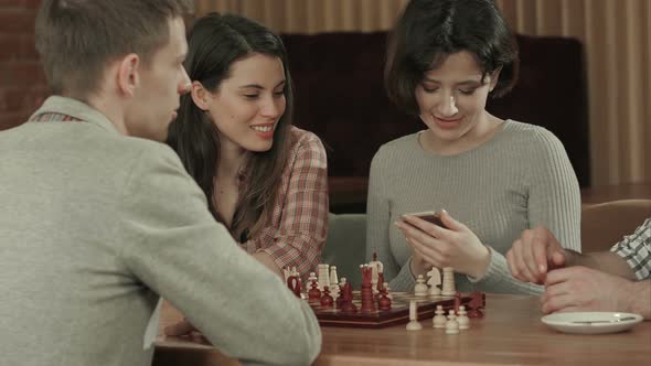 Girl Taking Photo of Playing Chess