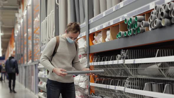 Man Buyer Chooses a Pvc Pipes in the Store