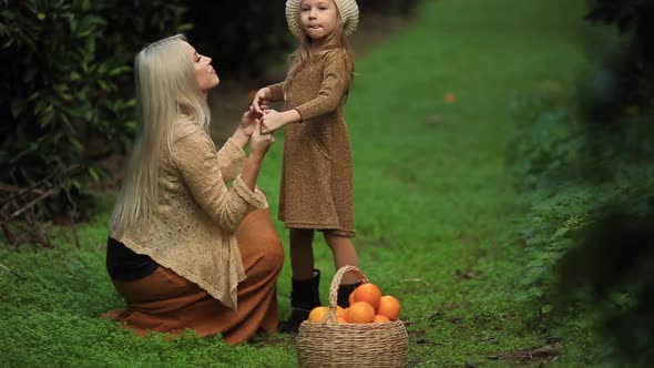 Happy Woman with Daughter in Sunny Garden