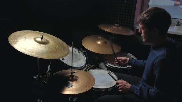 Man Sits Down to Play the Drum Set