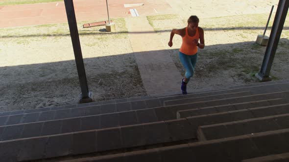 Front view of Caucasian female athlete exercising on steps at sports venue 4k